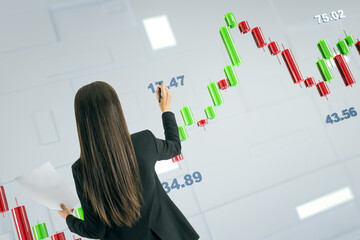 Wall Mural - Businesswoman analyzing financial chart with green and red candlesticks on modern transparent screen.