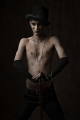 A creative portrait of a male model with creative makeup, a black trousers and a creative look.