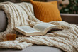 © JulieMeneghin - Photo d'un coin lecture cosy avec plaid, livre ouvert et source de lumière, ambiance cocooning hivernale et chaleureuse