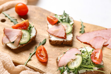 Wall Mural - Wooden board of delicious sandwiches with cream cheese, ham and vegetables, closeup