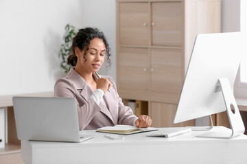 Wall Mural - young african-american qa engineer with notebook at her workspace in office