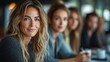 © DSimage - A blond woman with blue eyes is seated at a table among other women, engaging in conversation and enjoying the moment together.