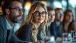 © DSimage - A group of people gathers around a table, each wearing glasses, engaged in conversation and sharing a lively atmosphere.