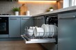 © Maryna - Modern kitchen interior shows clean white dishes ready to washed in electronic dishwasher. Gray cabinets, countertops part of contemporary design. Clean functional home style, tech equipment in