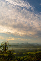 Wall Mural - Vertical Beautiful Mountain landscape foggy windy mountain range green landscape asian farm. Vertical Amazing Landscape mountain green field meadow white cloud blue sky sunrise. Countryside scenery