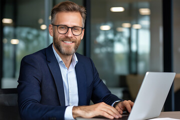Leinwandbilder - Smiling businessman working on laptop in modern office