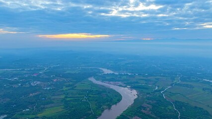 Wall Mural - Aerial view of The Ping River meanders through rural villages and rice fields, surrounded by mist-covered limestone mountains. The atmosphere is filled with tranquility and stunning natural beauty.