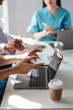 © R Photography - Two male doctors and a female nurse meet at a table in the hospital, collaborating on medical tasks, using laptops and computers, showcasing teamwork,and focusing on health,medicine,and patient care