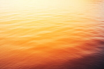 Aufkleber - A breathtaking sunset casts golden hues over a calm lake, with surrounding mountains enhancing the peacefulness of this natural landscape at dusk
