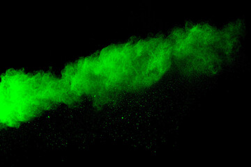 Wall Mural - green color powder explosion cloud on black background.green dust splash.