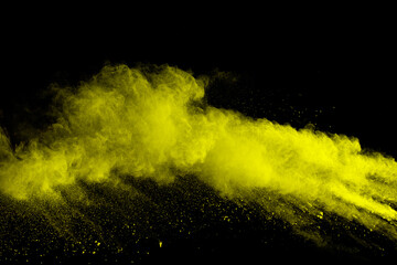 Wall Mural - yellow dust particles explosion on black background.yellow powder splash.