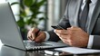 © MelodyStock - Professional Man Using Laptop and Smartphone in Modern Office