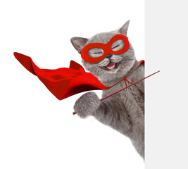 Aufkleber - Happy cat wearing superhero costume looking above from behind blank white banner and pointing on empty space. Isolated on white background