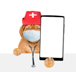 Aufkleber - Smart Mastiff puppy wearing like a doctor with stethoscope and protective mask showing big smartphone with white blank screen in it paw above blank white banner. isolated on white background
