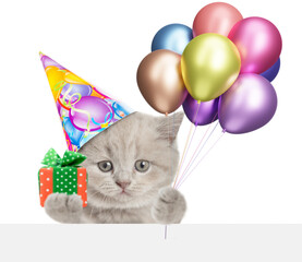 Poster - Cute tiny kitten wearing party cap holding gift box and balloons above blank white banner. isolated on white background