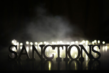 Wall Mural - Word Sanctions made of wooden block letters with dramatic lighting and smoke