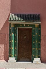 Wall Mural - Ornate wooden door with green mosaic tiles