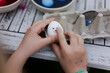 © Westend61 - Close-up of girl decorating Easter egg on garden table