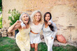 © Westend61 - Portrait of three excited women of different age embracing and cheering