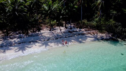 Wall Mural - Pristine turquoise waters lap against soft sandy shores as explorers wander the tranquil beaches of Koh Wai Island Thailand. Lush palm trees offer shade amid the tropical paradise.