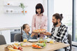 © sofiko14 - Caucasian family with young daughter enjoying pizza breakfast at home. Smiling parents and child sharing quality time in bright kitchen. Concept of family bonding and casual dining.