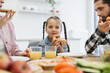 © sofiko14 - Caucasian family enjoying breakfast. Young girl with parents eating pizza at kitchen table. Happy morning meal with father, mother, child.