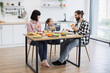 © sofiko14 - Caucasian family with adult couple and child eating pizza for breakfast in modern kitchen. Family bonding, happiness, and home meal concept with bright and minimalist decor.