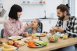 © sofiko14 - Caucasian mother and young daughter sitting together enjoying pizza for breakfast at home. Warm family moment with orange juice and smiling faces.