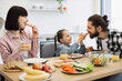 © sofiko14 - Caucasian family sharing pizza breakfast at home. Young parents and daughter enjoying morning meal together, creating joyful family time and bonding moments around kitchen table with healthy options.