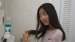 © FAMILY STOCK - Little Asian girl combing hair in the bathroom, caring for a child's hair