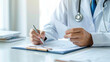© Vilaysack - doctor in white coat is sitting at desk, holding piece of paper and writing on clipboard, symbolizing medical documentation or patient care in professional setting