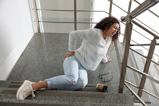 Wall Mural -  - woman with injured back on stairs in building after fall. dangerous accident