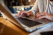 © Davor - Senior mature woman working on laptop in modern kitchen