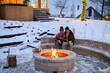 © Halfpoint - Older couple has lit a fire in garden fire pit. Seniors watching flames, relaxing and drinking hot tea.