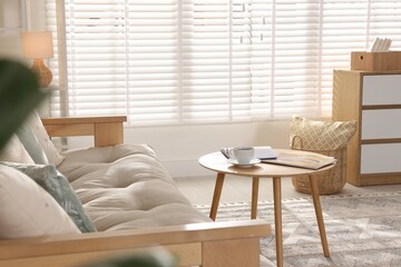 Poster - Beautiful sofa with cushions and coffee table in living room. Interior design