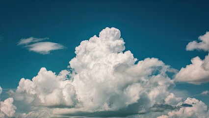 Sticker - Fluffy white clouds scattered across a vibrant blue sky with subtle variations in shades creating a serene and tranquil atmosphere.