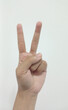 © pakn - Close up Asian female hand in scissors gesture, number two, victorious gesture, sign finger arm and hand isolated on a white background copy space symbol