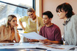 © Jacob Lund - College students and a teacher reviewing feedback on assignments in a classroom setting