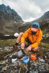 Wall Mural - Man cooking camping food outdoor using gas stove gear on picnic in mountains backcountry kitchen  - travel solo hiking survival trip adventure vacations summer wild tourism