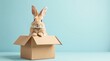 © vattana - Adorable bunny rabbit sitting inside a cardboard box against a light blue background