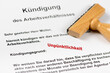 © Wolfilser - Ein Holzstempel liegt auf der Kündigung des Arbeitsvertrages wegen Unpünktlichkeit