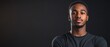 © BISO - A handsome young African American man stands in front of a black background, providing space for text.