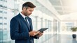 © Kannika - Copayment benefits. Professional man using a tablet in a modern office setting.