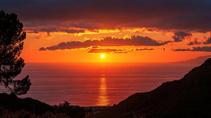 Wall Mural - Vibrant sunset over ocean, hills silhouette.