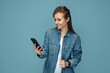 © Screaghin - Cheerful young woman chatting on smartphone over blue background. Blogger