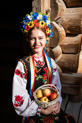 Wall Mural - Woman in traditional costume. Ukrainian woman with a basket of apples. A young woman in a national Ukrainian costume. Embroidery. Ukrainian national clothing - embroideries. Corolla	