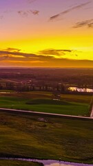 Sticker - vertical video of a timelapse of an open field landscape with a lake at sunset and a road