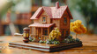 © Людмила Мазур - Miniature wooden house with a gavel on top of it. The gavel is placed on a wooden stand, giving the impression of a miniature courtroom. The house is surrounded by fake grass and trees