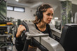 © Miljan Živković - Focused woman use gym machine for strength training workout at gym