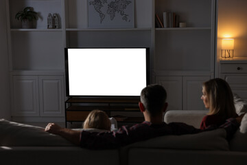 Wall Mural - Family watching TV on sofa at home in evening